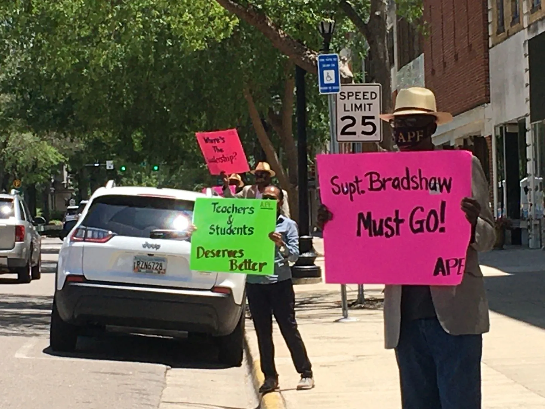A.P.E. advocates holding signs outside a school district office